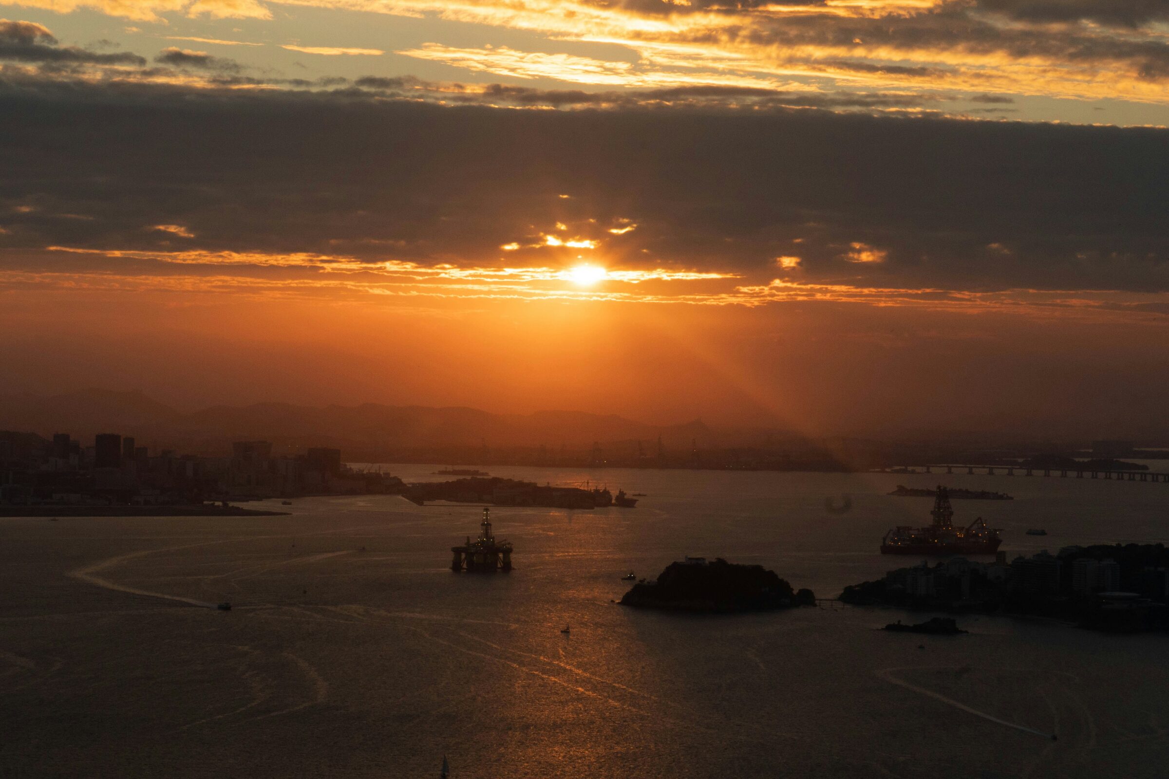 Pôr-do-sol na Baía de Guanabara com plataformas offshore — operação DMS em Niterói/RJ